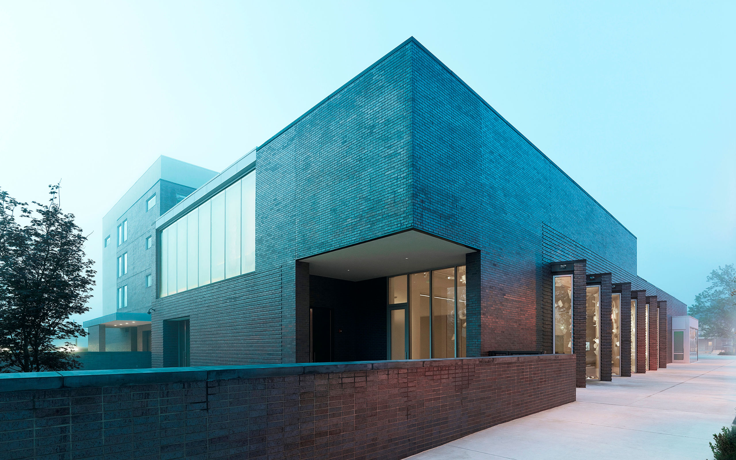 21c Museum Hotel Bentonville with dark brick facade and landscape wall.