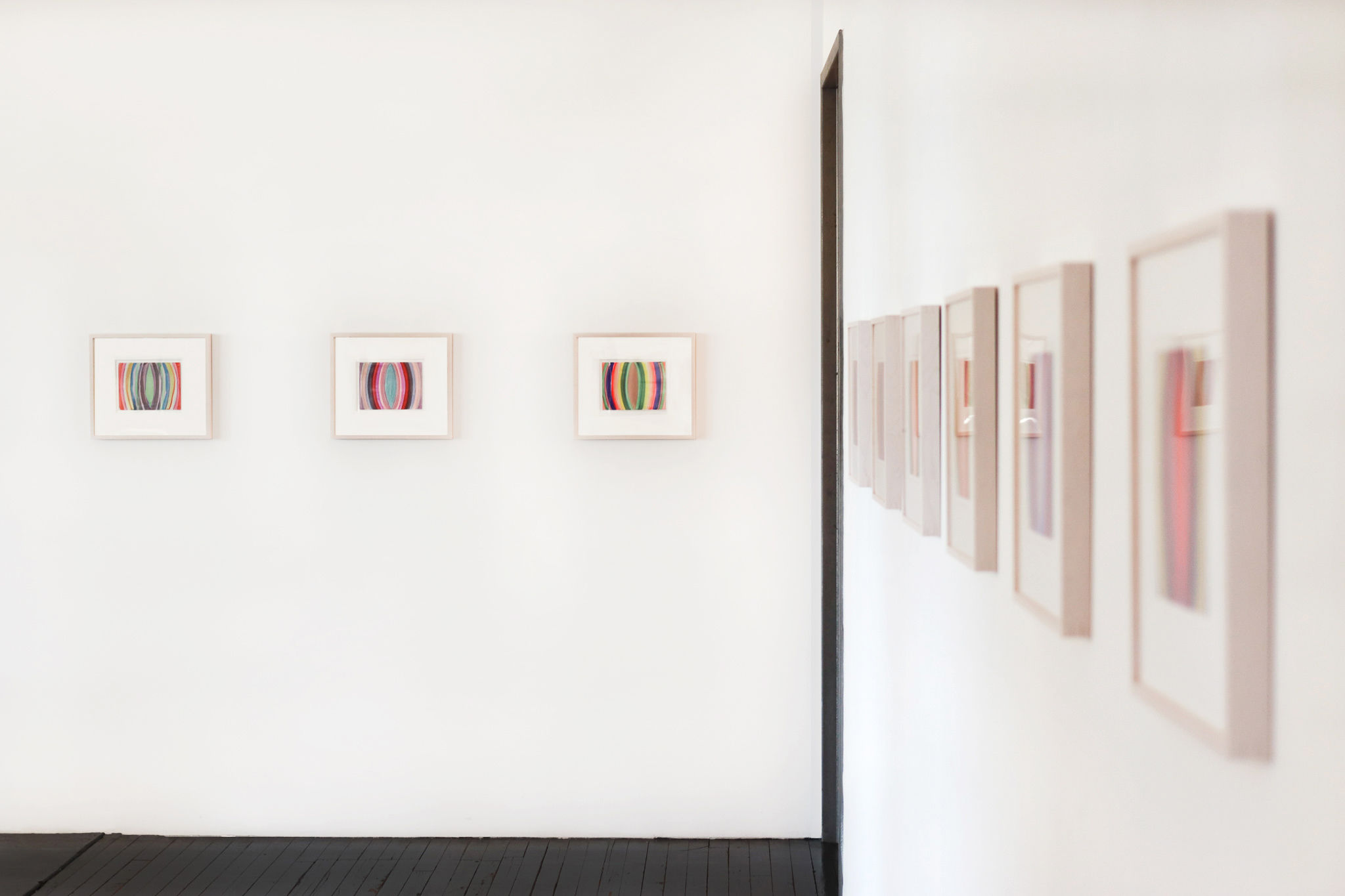 Framed paintings in foreground and background.