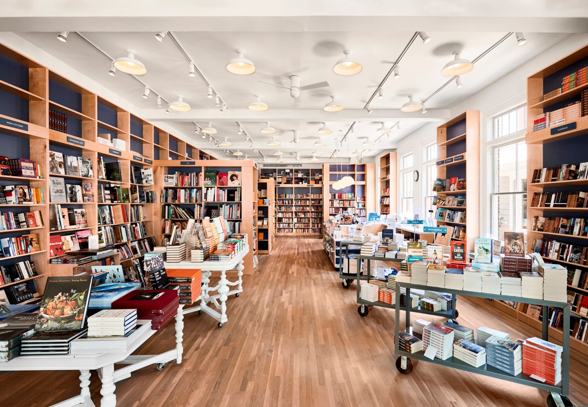 Bright bookstore with shelves full of books and display tables.