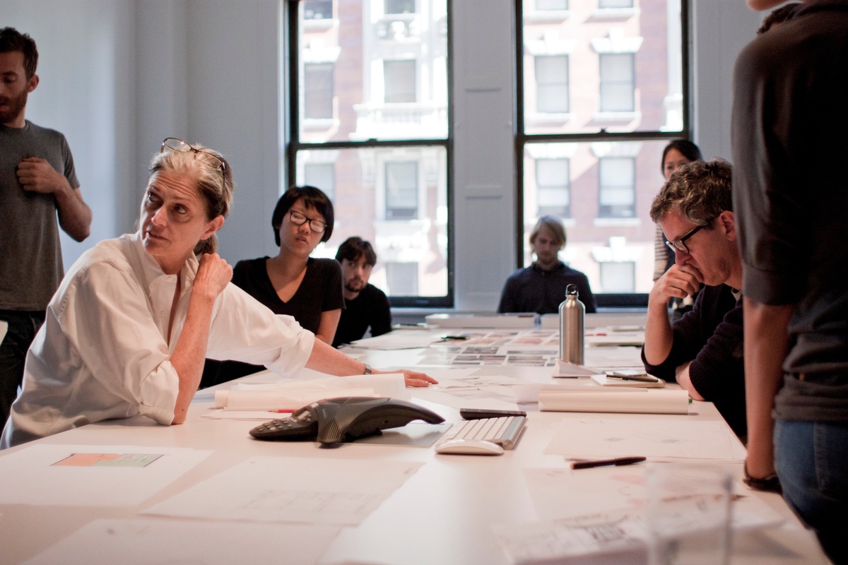 Design charette with table andTenBerke staff looking over drawings.